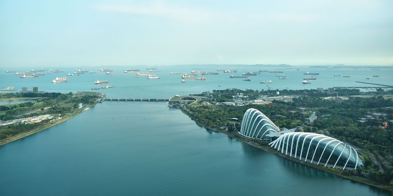 Aerial view of the garden domes and Marina Barrage beside the sea