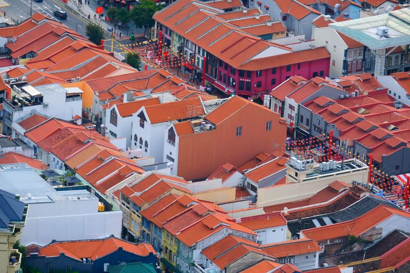 Aerial view of vibrant red-tiled roofs in a traditional urban neighborhood, capturing cultural charm.