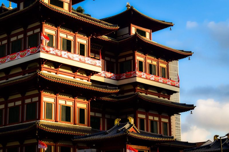 Traditional pagoda architecture of a Buddhist temple in Singapore, captured under warm sunlight.