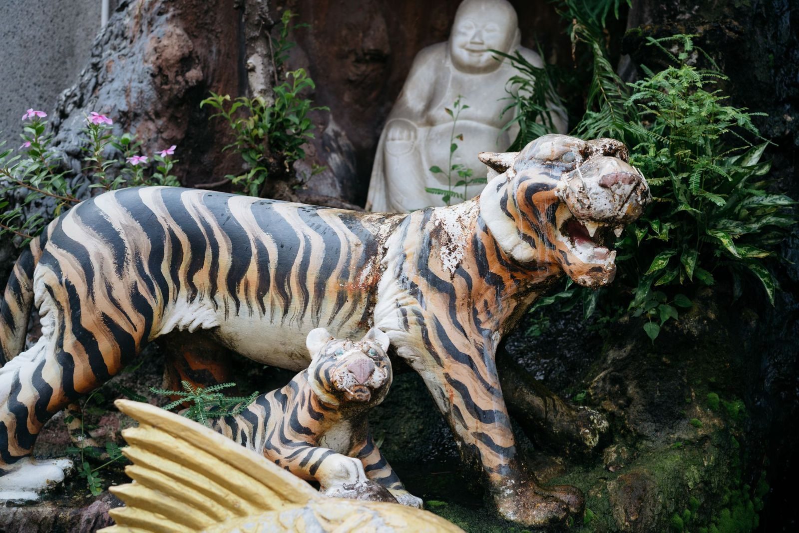 Ornate tiger sculptures at a vibrant Thai shrine, embodying cultural spirituality and devotion.