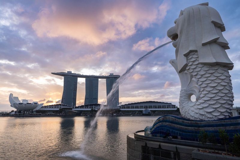 Capture of Singapore's Merlion and Marina Bay Sands at sunset, showcasing modern architecture.