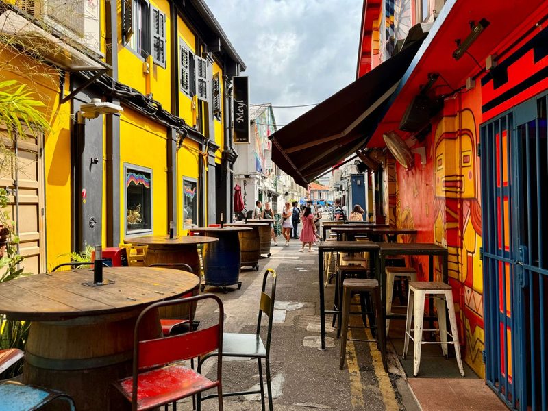 A lively alleyway featuring colorful street art and outdoor cafes, perfect for urban exploration.