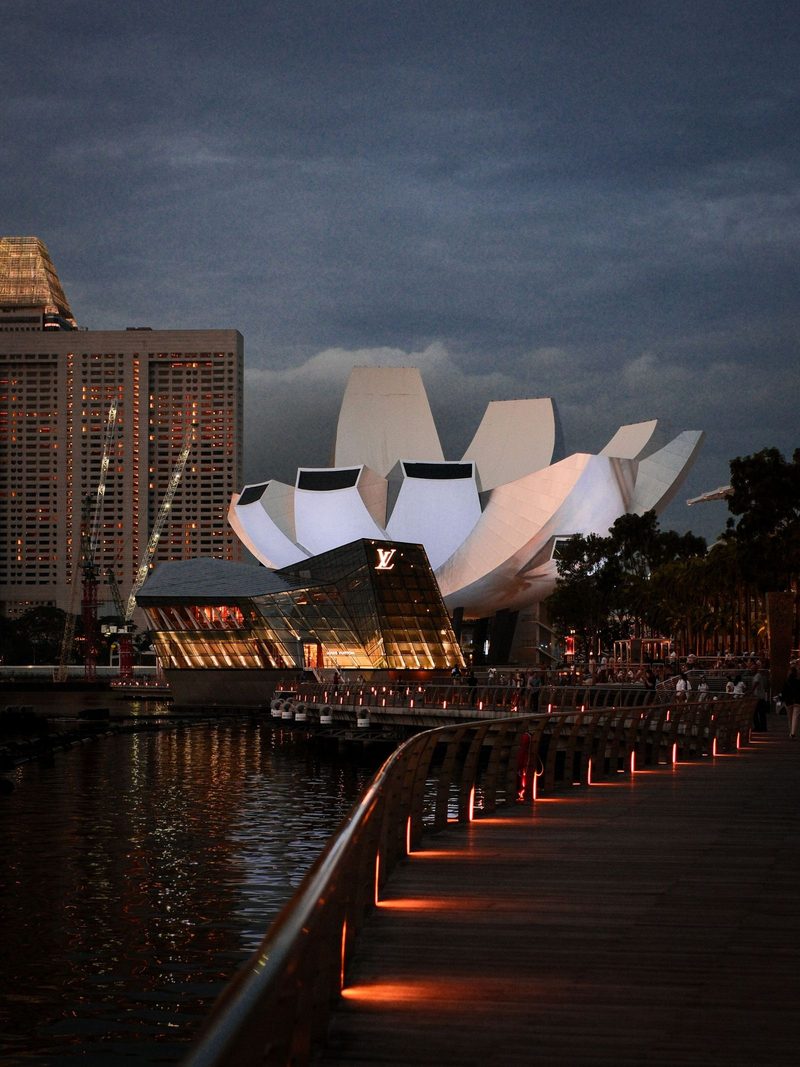 Explore the illuminated Marina Bay Waterfront in Singapore with stunning architecture and serene reflections at dusk.