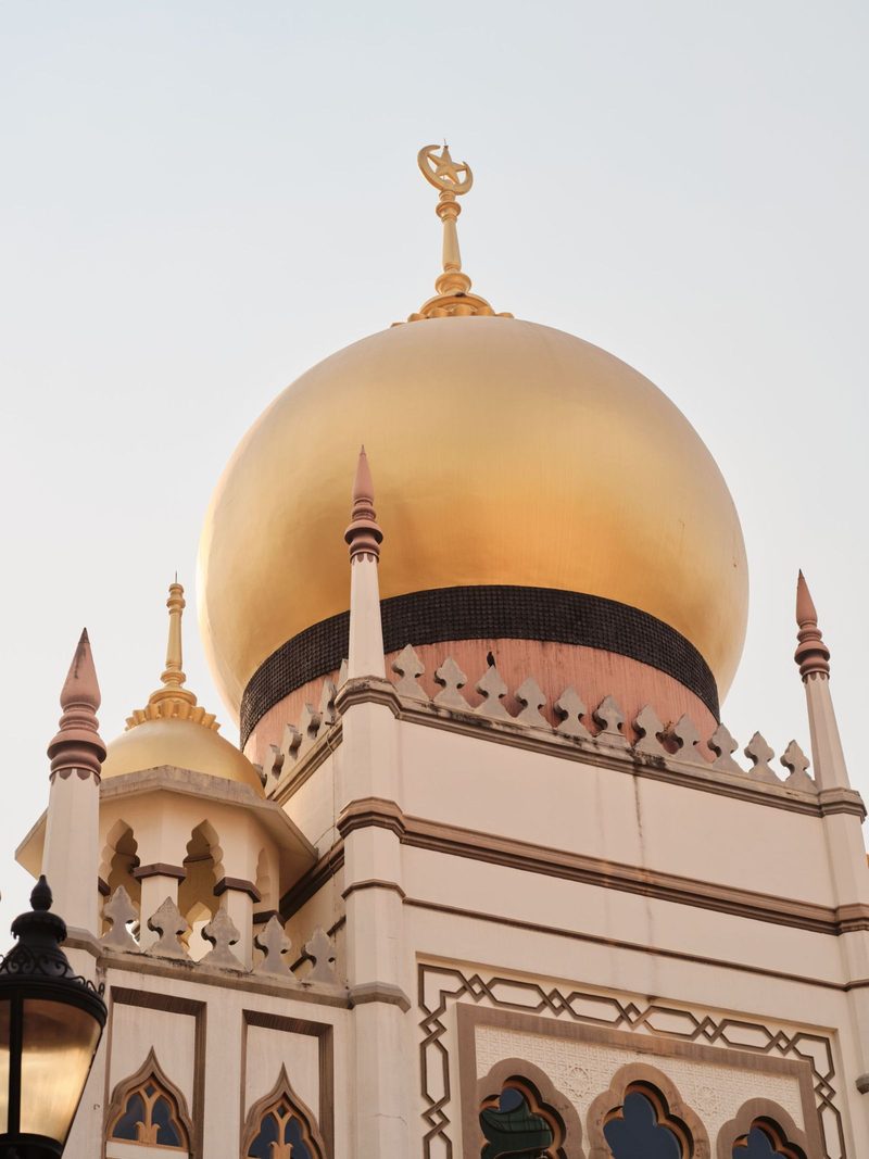 Capture of the iconic golden dome of Sultan Mosque against a clear sky in Singapore.