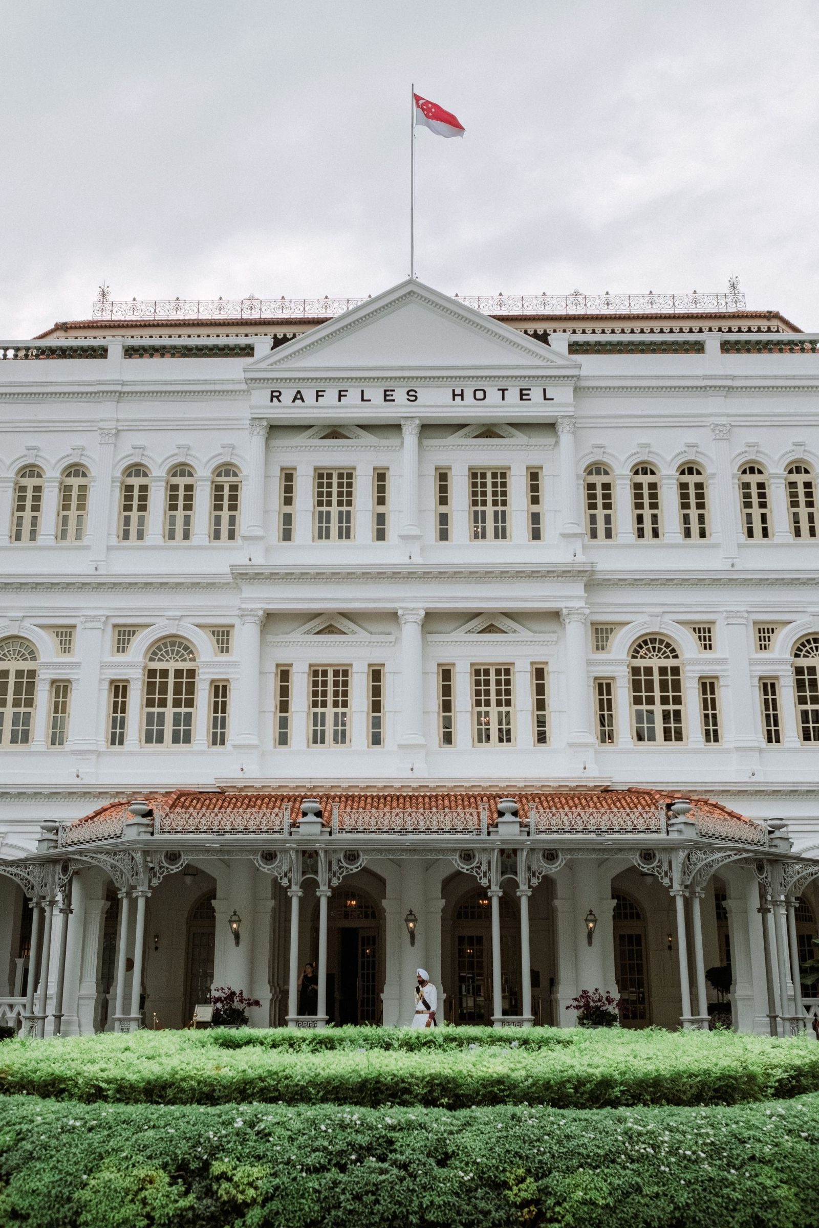 Front view of the historic Raffles Hotel in Singapore, showcasing its classic colonial architecture.