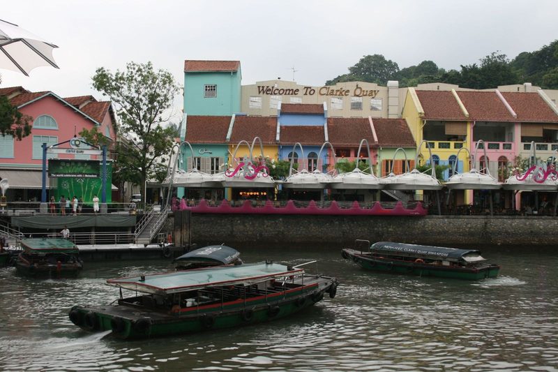 Colorful buildings and traditional boats at Clarke Quay, Singapore's vibrant riverside quay.
