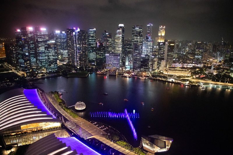 Breathtaking aerial view of Singapore's illuminated skyline at night, showcasing modern architecture and vibrant city life.