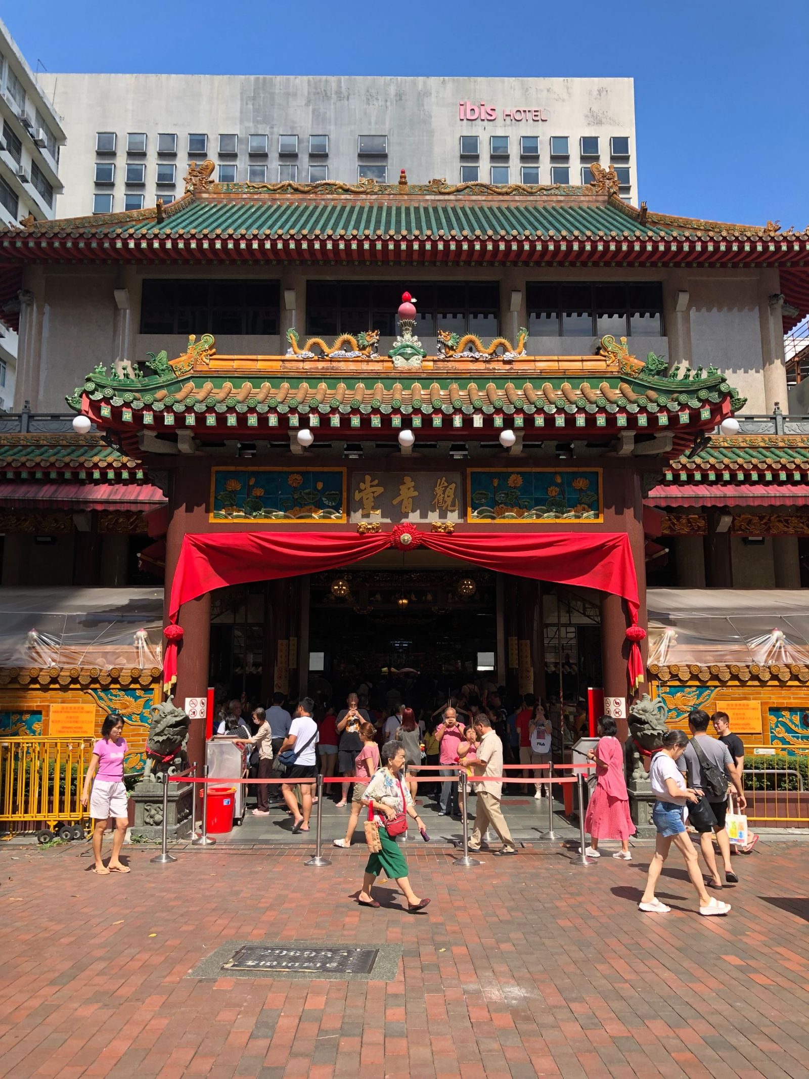 Thian Hock Keng Temple bustling with visitors on a sunny day in Singapore.