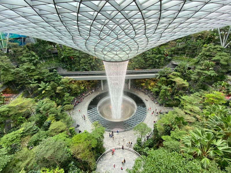 Breathtaking view of the indoor waterfall and lush garden at Jewel Changi Airport, Singapore.