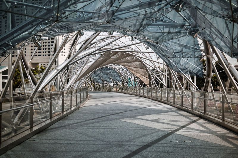 Intricate steel and glass structure of Helix Bridge in Singapore showing architectural detail.
