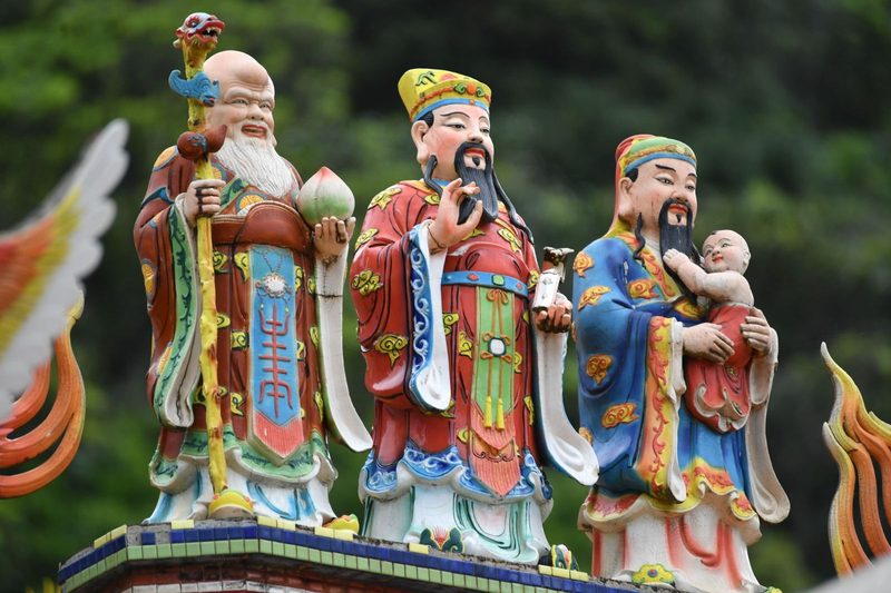 Vibrant statues of Taoist deities captured outdoors, showcasing traditional design.